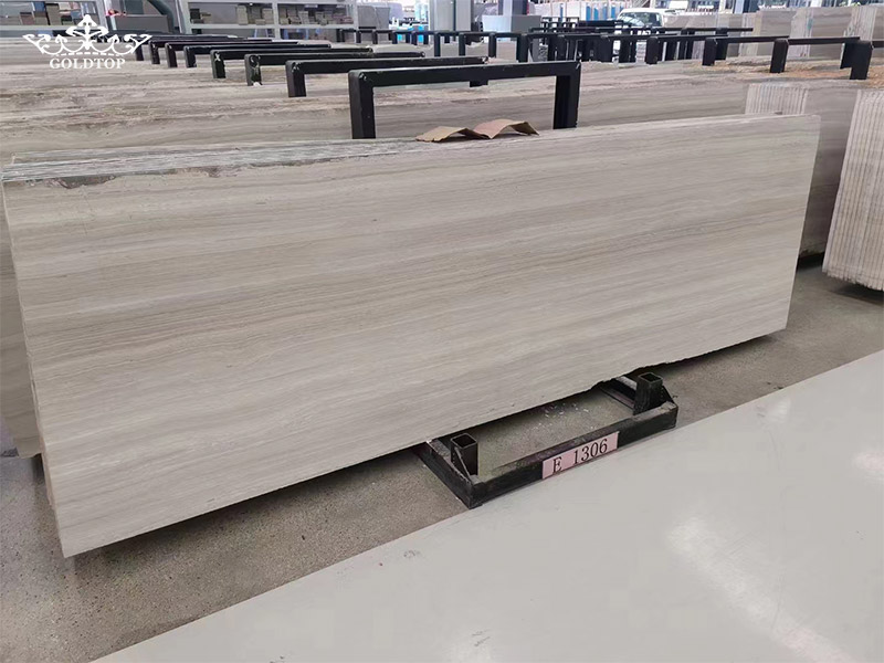 White Wood Marble has a soft light grey-white base with natural mineral patterns running through the stone.